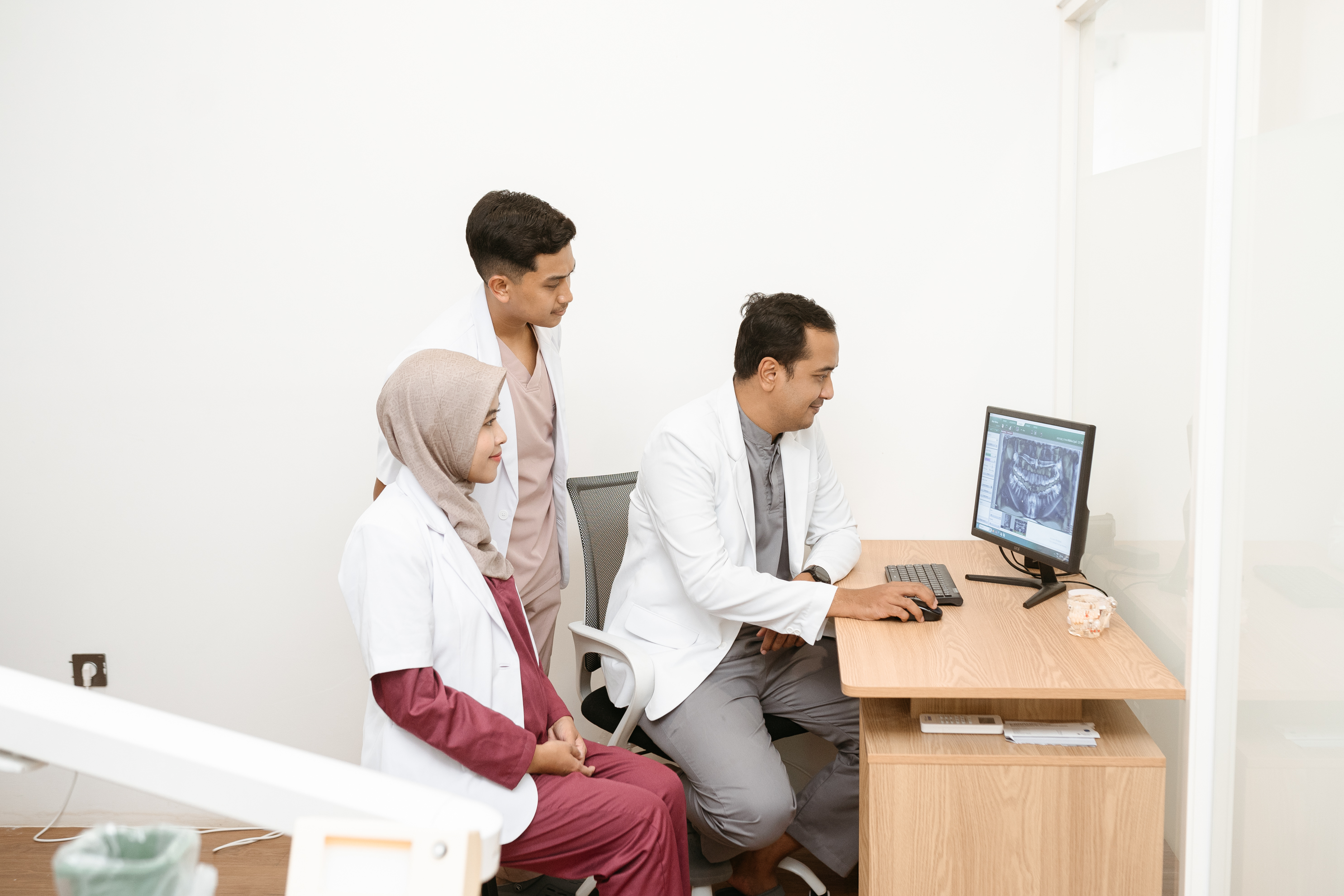 Dokter gigi melakukan pemeriksaan menggunakan teknologi digital di INTRO Dental